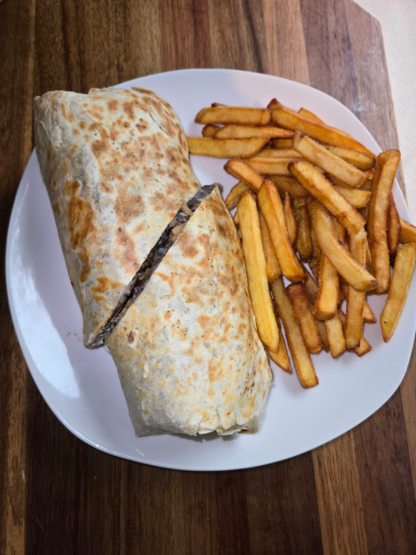 Grilled burrito cut in half with french fries