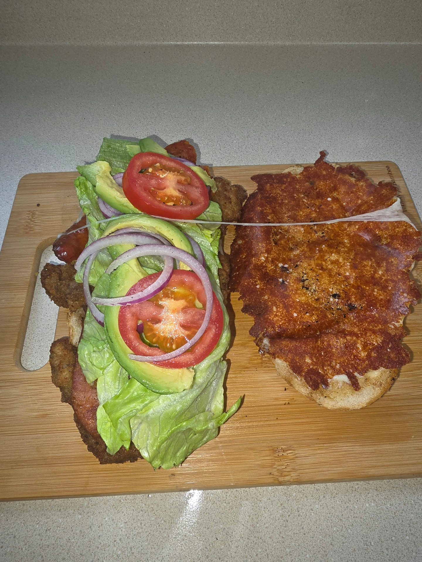 Open torta with breaded meat, lettuce, tomato, avocado and red onion
