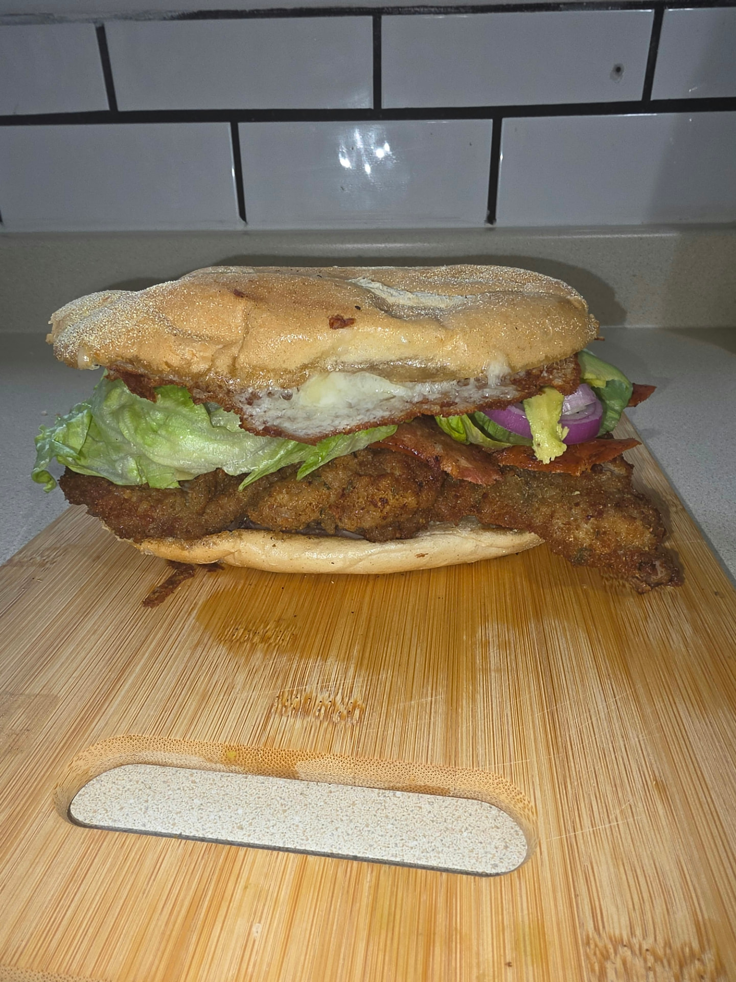 Torta with breaded meat, lettuce, bacon, avocado and red onion